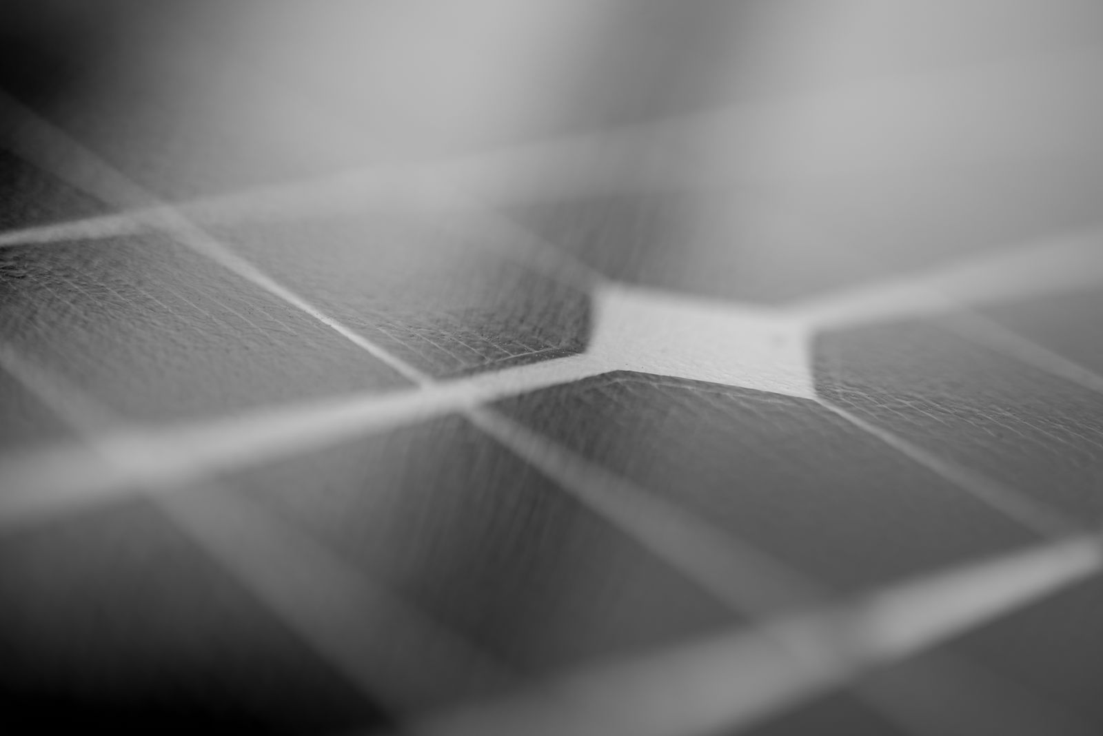 Detailed monochrome close-up of a solar panel surface showing texture and grid pattern.