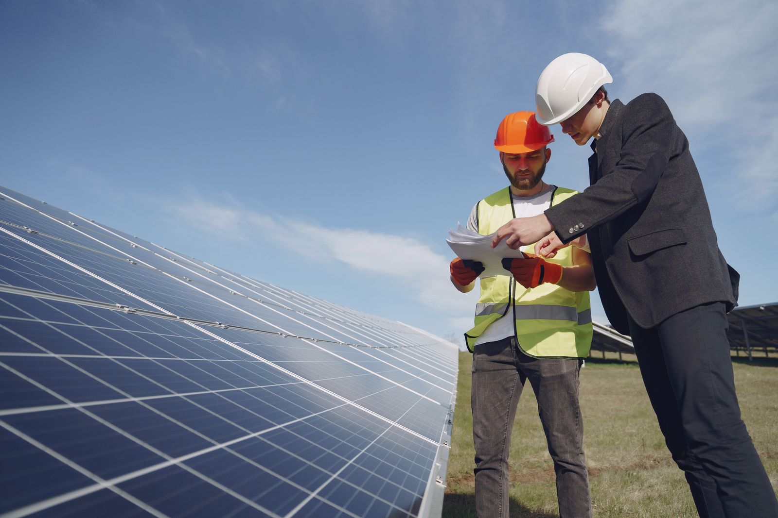 Engineer inspecting a rooftop solar array with monitoring equipment